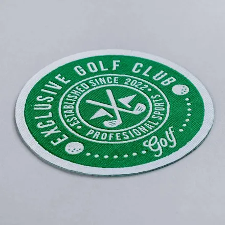 Round woven patch in green and white reading Exclusive Golf Club, with crossed golf clubs