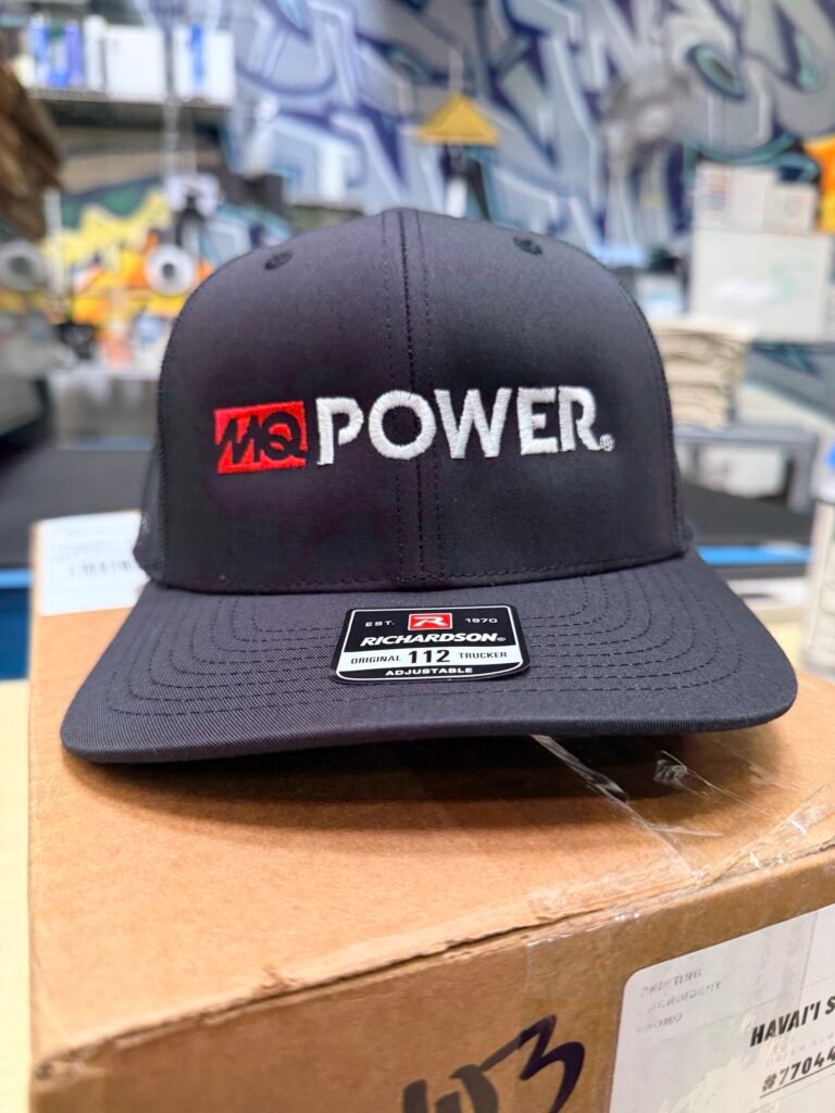 Black Richardson 112 trucker cap with raised white puff embroidered lettering