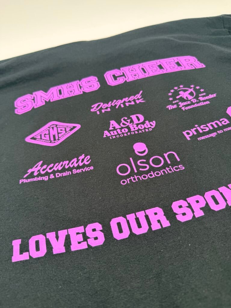 Black school cheer shirt screen printed with sponsor logos in pink ink, printed in Phoenix Arizona