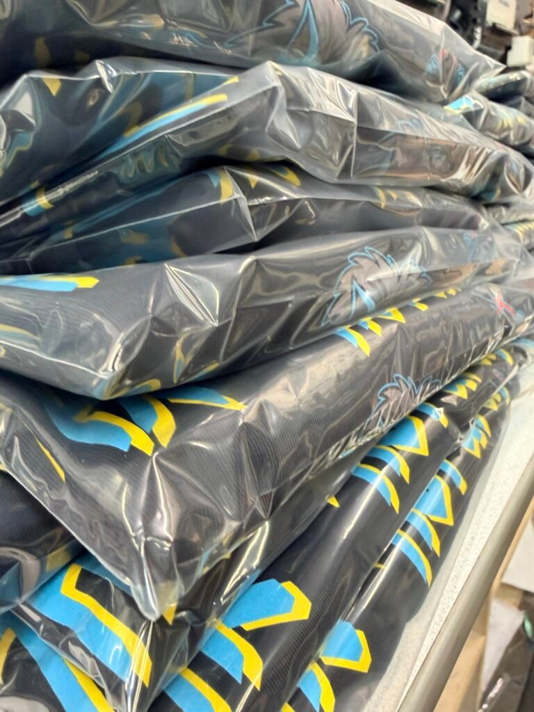Stack of screen printed shirts individually poly-bagged and ready for delivery from the Phoenix shop